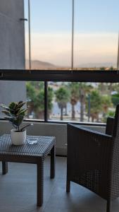 a table and a chair with a potted plant on it at Concón, Edificio Vista Higuerillas, Costa de Montemar, A PASOS DE LA PLAYA in Concón