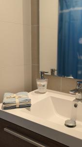 a bathroom sink with a towel and a mirror at Concón, Edificio Vista Higuerillas, Costa de Montemar, A PASOS DE LA PLAYA in Concón