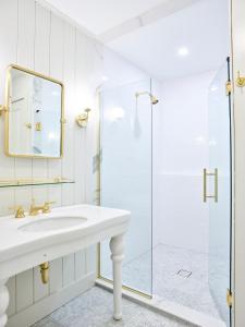 a white bathroom with a sink and a shower at The Lake House on Canandaigua in Canandaigua