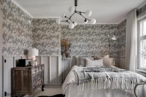 ein Schlafzimmer mit einem Bett und einem Kronleuchter in der Unterkunft Bruket i Wiared in Borås