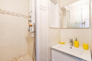 La salle de bains blanche est pourvue d'une douche et d'un lavabo. dans l'établissement double appartement, saint michel, parking, wifi, à Toulouse