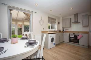 a kitchen with a table and a stove top oven at Wigmore Lodge - FREE Parking & Airport & M1 & Contractor & Leisure in Luton
