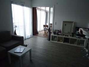 ein Wohnzimmer mit einem Sofa, einem Tisch und einem Spiegel in der Unterkunft Le Neptune in Contis-les-Bains