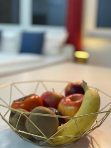 a bowl of fruit on a counter with a banana and tomatoes at Lux Apartment near Frankfurt! in Mörfelden-Walldorf