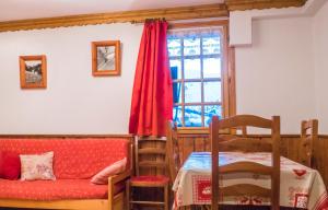 un soggiorno con divano rosso e finestra di appartement charmille a Saint-Martin-de-Belleville