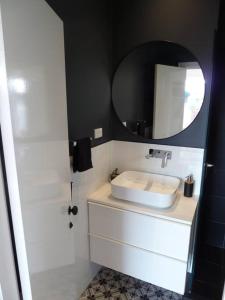 a bathroom with a white sink and a mirror at Studio A - Small Gem On The Busy Road in Perth