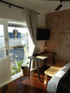 a bedroom with a desk and a window with a balcony at Studio A - Small Gem On The Busy Road in Perth