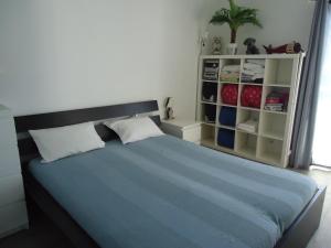 ein Schlafzimmer mit einem großen blauen Bett und einem Schrank in der Unterkunft Le Neptune in Contis-les-Bains