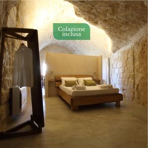 ein Schlafzimmer mit einem Bett und einem Spiegel in einem Zimmer in der Unterkunft Casa Vacanza La Cava nel Barisano Suite Matera in Matera