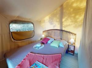 a bedroom with a large bed with a window at Campasun Camping de l'Aigle in Aiguines