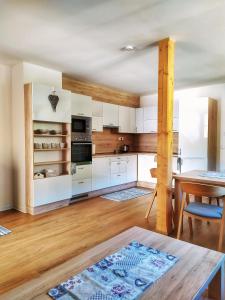 a kitchen with white cabinets and a wooden table at Apartmány u Ivanky, Polanský dvůr 1149 in Velké Karlovice