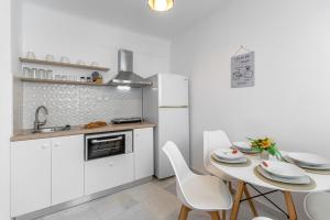 a kitchen with a table and chairs and a refrigerator at Optasia - Naxos Center Cozy House in Naxos Chora +9 photos