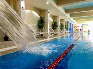 a pool with a water slide in a building at AquaSun Family Hotel in Sandanski
