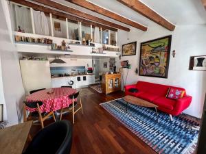 uma sala de estar com um sofá vermelho e uma mesa em Une ambiance bohème sur les toits de Sainte-Anne em Montpellier