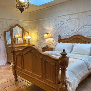 1 dormitorio con cama grande de madera y pared de piedra en Nellie's Farmhouse, en Carlingford