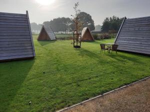 Vragender的住宿－Achterhoeks Goed, Minicamping in Vragender，一个带三个帐篷和桌椅的庭院