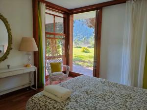 Schlafzimmer mit einem Bett und einer Glasschiebetür in der Unterkunft Villa Montgrau in Llano de Gorra