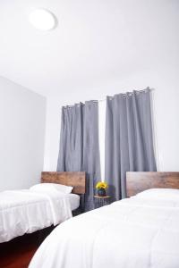 two beds in a room with gray curtains at Cozy apartment 2nd 10min Walk Downtown and City View in Providence