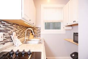 una cocina con armarios blancos y fregadero en Cozy apartment 2nd 10min Walk Downtown and City View, en Providence