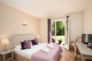 カルカソンヌにあるHôtel La Bastide Saint Martinのベッドと机と窓のある寝室