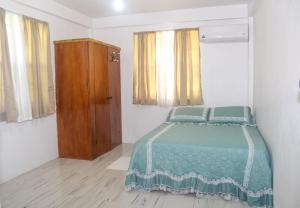 1 dormitorio con 1 cama y armario de madera en Comfort Air B & B, en Mount Gay
