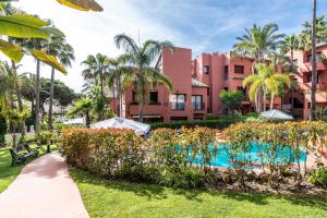 un resort con piscina e palme di Luxury Spacious Penthouse & garage 150m to Beach a Marbella