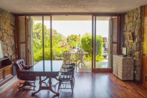 Llano de Gorra的住宿－Villa Montgrau，一间带桌椅的用餐室和一个阳台