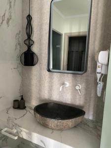 a bathroom with a large stone sink and a mirror at Siviris Golden Beach in Siviri