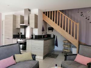 sala de estar con 2 sofás y cocina en Le Cabanon de Laura, en LʼIsle-sur-la-Sorgue
