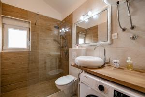 a bathroom with a sink and a toilet and a shower at Holiday Home Aria in Nin