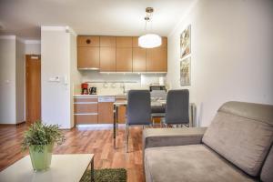 a living room and kitchen with a couch and a table at Apartamenty na Wyspie - Villa Mistral - Apartamenty z sypialnią i parkingiem in Świnoujście