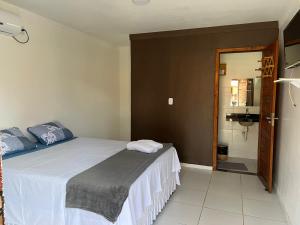 a bedroom with a large bed and a bathroom at Pousada Marina in Barreirinhas