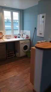 uma cozinha com um lavatório e uma máquina de lavar roupa em Le Bleu Roi - Appartement calme proche de la Gare em Caen