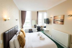 Habitación de hotel con cama y TV en Palm Court Hotel en Great Yarmouth