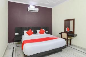 ラムナガルにあるCorbett Wildlife Homestayのベッドルーム1室(大型ベッド1台、赤い枕付)