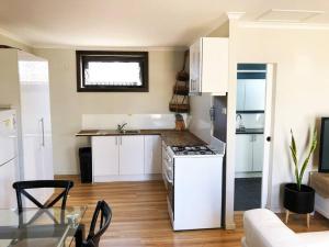a kitchen with white cabinets and a stove top oven at The Central Shed - 10B in Geraldton