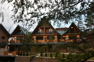 Una casa grande con un gran porche con luces. en Brvnara Mont 1, en Zlatibor