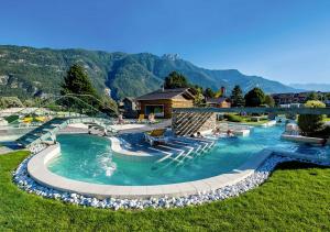 una piscina con gente sentada en el agua en Hôtel des Bains de Saillon, en Saillon