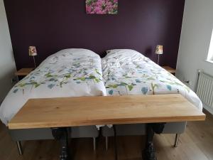un letto con un tavolo in legno accanto ad esso di Casa Paz a Elst