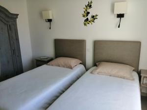 dos camas sentadas una al lado de la otra en un dormitorio en Le Cabanon de Laura, en LʼIsle-sur-la-Sorgue
