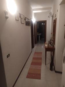 - un couloir avec une chambre dotée d'une table et d'un tapis dans l'établissement Casa vacanze, à Berchidda