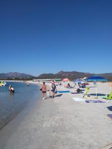 een groep mensen op een strand met water bij Casa vacanze in Berchidda