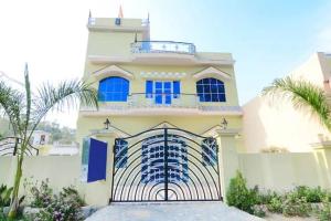 a white house with a gate in front of it at Corbett Wildlife Homestay in Rāmnagar