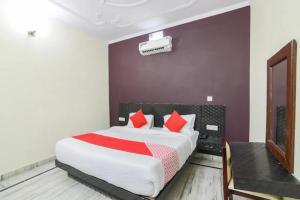 una camera da letto con un grande letto con cuscini rossi di Corbett Wildlife Homestay a Ramnagar