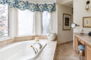 ein großes Bad mit einer Badewanne und Fenstern in der Unterkunft Sur La Plage in New Buffalo