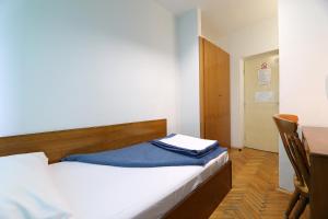a small bedroom with a bed and a desk at Rijeka Budget Rooms in Rijeka