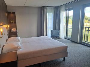 une chambre d'hôtel avec un lit et une chaise dans l'établissement Parkhotel Horst - Venlo, à Horst