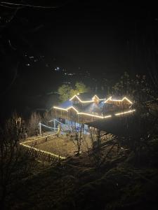 ein nachts beleuchtetes Haus mit Licht in der Unterkunft THE OFFBEAT CHALET in Jibhi