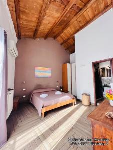 ein Schlafzimmer mit einem Bett und einer Holzdecke in der Unterkunft Kasa Kala Rooms & Apartments in Palermo