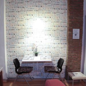 una mesa con dos sillas frente a una pared en Guest House Benny, en Reggio Emilia